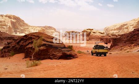 Avventure safari jeep auto nel deserto di Wadi Rum, Giordania, Medio Oriente, conosciuta come la Valle della Luna. Sabbie rosse, cielo con foschia. Designazione come UNESCO Foto Stock