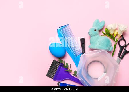 Accessori per parrucchieri con uovo di Pasqua, coniglio e fiori su sfondo rosa Foto Stock