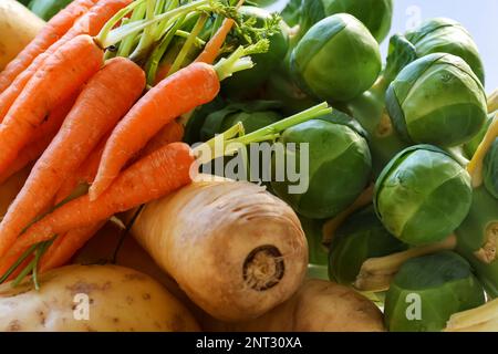 Selezione di verdure fresche crude. Carote con gambi verdi, pastinaca, cavolini di bruxelles e patate. Irlanda Foto Stock