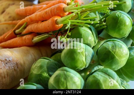 Selezione di verdure fresche crude. Carote con gambi verdi, pastinaca, cavolini di bruxelles e patate. Irlanda Foto Stock