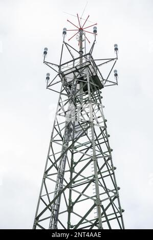 Torre radar con diversi dispositivi di misurazione e sensori, vista a basso angolo durante le giornate nuvolose, ripresa verticale Foto Stock