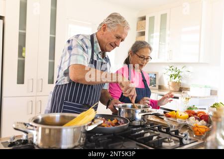 Buona coppia senior diverse cucina cena in cucina Foto Stock