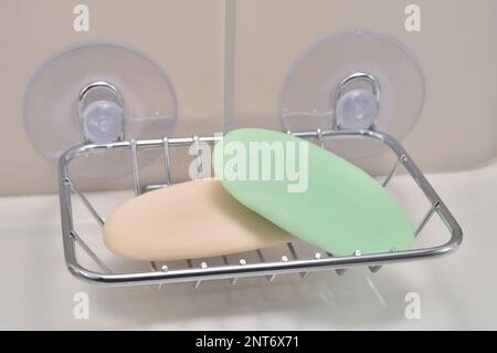 Vassoio per sapone cromato, piatto di supporto montato a parete, lavabo in porcellana bianca, piastrelle beige, barre d'avorio usate verdi e cremose, grande dettaglio closeup orizzontale Foto Stock