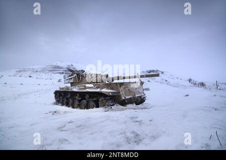 Un carro armato abbandonato al confine siriano in una giornata nevosa Foto Stock