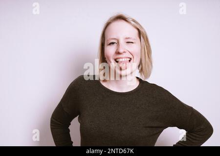 sciocca giovane donna che scherzava in giro per uscire dalla lingua e strizzarla Foto Stock