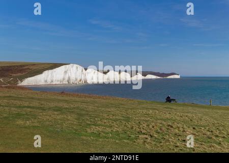 SEAFORD, SUSSEX/UK - 5 APRILE : uomo seduto su una panchina che si affaccia sulle sette Sorelle vicino a Seaford in Sussex il 5 aprile 2018. Uomo non identificato Foto Stock