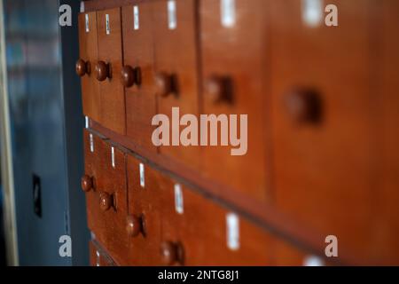 Un armadietto di legno con la funzione di memorizzare piccoli oggetti nella biblioteca della scuola Foto Stock