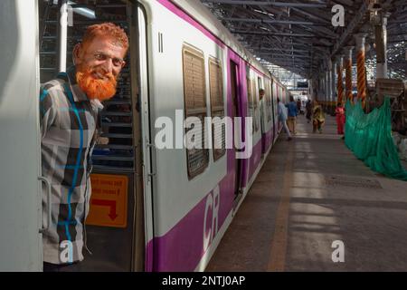 Un uomo musulmano con la barba color hennè si trova all'ingresso di un bogey di un treno suburbano al Chhatrapati Shivaji Maharaj Terminus di Mumbai, India Foto Stock