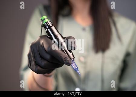 Strumenti per la procedura di correzione delle sopracciglia. Macchina per il trucco permanente in mano femminile. Tatuaggio delle sopracciglia. Sopracciglia per microblading Primo piano Foto Stock