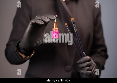 Henné naturale e strumenti in mani estetista-make artist per la correzione delle sopracciglia in un salone di bellezza. Cura professionale del viso. Foto Stock