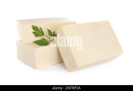 Blocchi di delizioso tofu crudo con prezzemolo su sfondo bianco Foto Stock