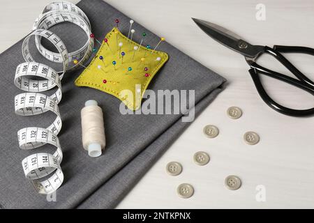 Set di accessori e accessori per cucire su tavolo bianco, vista dall'alto Foto Stock