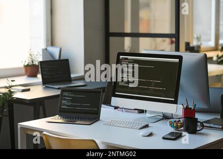 Ambiente di lavoro moderno di programmatore con computer sul tavolo in ufficio moderno Foto Stock