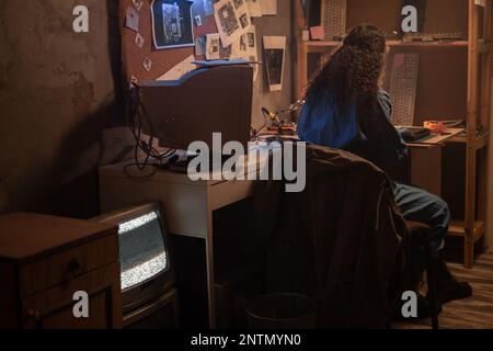 Tecnico di assistenza informatico che ripara i componenti rotti aggiorna il sistema, la memoria sul vecchio laptop. Il tecnico lavora in officina di riparazione retrospettiva Foto Stock