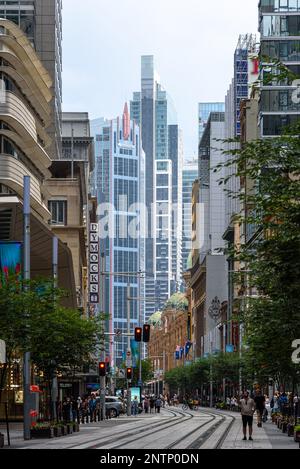 I tram che percorrono George Street nel quartiere centrale degli affari di Sydney in una giornata estiva Foto Stock