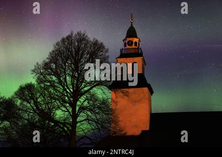 Hagebyhöga, Svezia. 27th, febbraio 2023. Tempo stagionale, aurora boreale durante la notte verso il martedì nella contea di Östergötland, Svezia. Nella foto: La chiesa di Hagebyhöga, appena fuori dalla città di Vadstena, Svezia. Un'aurora (aurora o aurora), nota anche come le luci polari, è un'esposizione di luce naturale nel cielo della Terra, vista prevalentemente nelle regioni ad alta latitudine. Credit: Jeppe Gustafsson/Alamy Live News Foto Stock