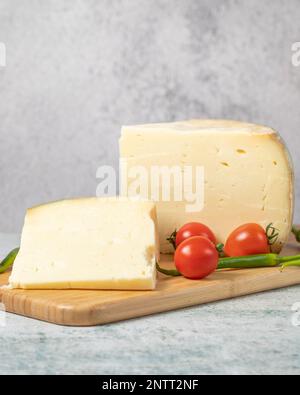 formaggio a rotelle. Formaggio a base di latte vaccino su una lavagna a fogli mobili in legno. Formaggio turco Gruyere Foto Stock
