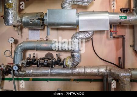 Commutazione industriale di tubi di riscaldamento nel seminterrato Foto Stock