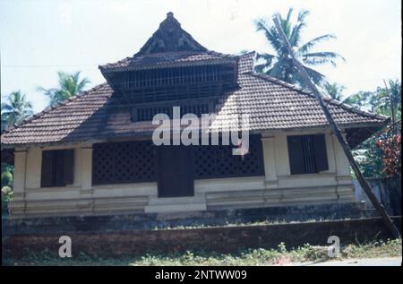 Kerala Case:- la forma visiva più distintiva dell'architettura Kerala è il lungo, ripido tetto inclinato costruito per proteggere le pareti della casa e per resistere al monsone pesante, normalmente posato con piastrelle o labirinto di paglia di foglie di palma, sostenuto su un telaio del tetto in legno duro e legno. Il Kerala è uno stato che riceve le precipitazioni per almeno 6 mesi in un anno e per un tale clima, i tetti inclinati sono sempre i migliori. L'architettura del Kerala segue Thatchu Shasthra, una scienza della Falegnameria che regola le sfumature dell'edificio/costruzione. Foto Stock