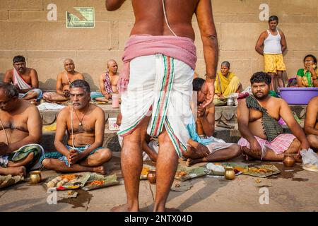 Pellegrini facendo una offerta rituale e pregare, ghats nel fiume Gange, Varanasi, Uttar Pradesh, India. Foto Stock