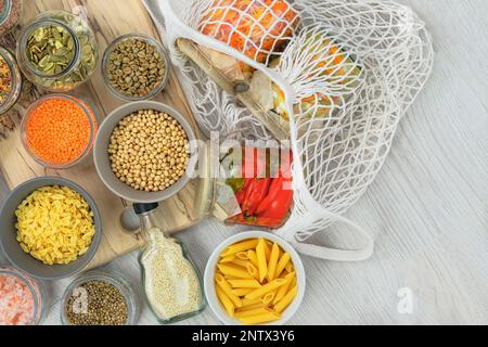 Alimenti biologici in negozio zero rifiuti. Vari prodotti agricoli in vasetti di vetro su sfondo di legno chiaro. Spazio di copia. Vista dall'alto. Foto Stock