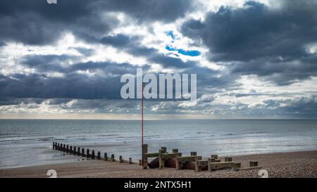 Un gabbiano si trova sulla sommità di un'asta di navigazione attaccata ad una vecchia groyne di legno sulla spiaggia di ciottoli a Bognor Regis, West Sussex, UK. Foto Stock