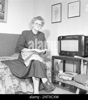 Ascoltatori radio in passato. Quattro giovani donne nello spogliatoio di un teatro di Stoccolma si siedono vestite con i loro abiti da palco e si riuniscono intorno ad un piccolo apparecchio radio, ascoltando con ansia. Sulla parte anteriore della radio è presente una scala e quando si ruota la manopola accanto ad essa in modo che il puntatore si trovi al centro del nome di una stazione, la stazione era lì. Oltre alle trasmissioni FM, hanno anche ascoltato le radio straniere a onde lunghe. Svezia nel 1949 Kristofferson Ref AT25-10 Foto Stock