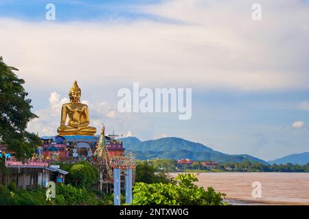 Magnifica statua dorata del Buddha adagiato su un cielo blu chiaro. Le dimensioni impressionanti della statua e i dettagli squisiti si distinguono splendidamente contro se Foto Stock