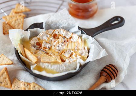 camembert formaggio francese morbido cotto in forno con miele e timo, vista laterale Foto Stock