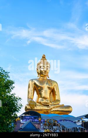 Magnifica statua dorata del Buddha adagiato su un cielo blu chiaro. Le dimensioni impressionanti della statua e i dettagli squisiti si distinguono splendidamente contro se Foto Stock