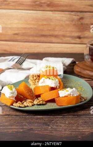 Dessert cremoso di zucca. Dolci Ramadan Turchi. Dessert di zucca con sorbetto su sfondo grigio. Foto Stock