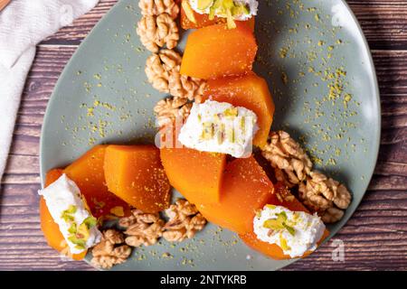 Dessert cremoso di zucca. Dolci Ramadan Turchi. Dessert di zucca con sorbetto su sfondo grigio. Vista dall'alto Foto Stock