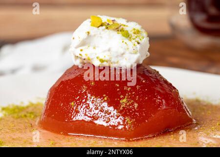 Dessert di cotogna con sorbetto su fondo grigio. Dolce cremoso di mele cotogne. Dolci Ramadan Turchi. Primo piano Foto Stock