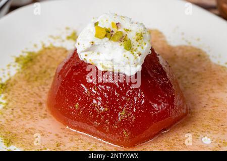 Dessert di cotogna con sorbetto su fondo grigio. Dolce cremoso di mele cotogne. Dolci Ramadan Turchi. Primo piano Foto Stock