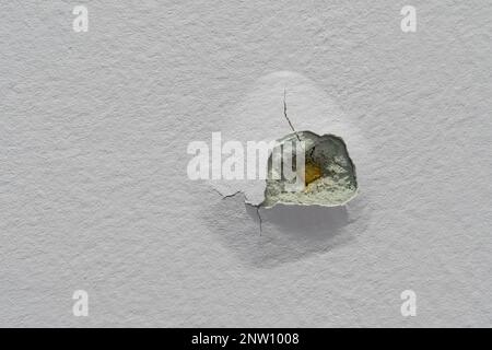 Vista ravvicinata della struttura della parete viola incrinata e dei fori. Foto Stock