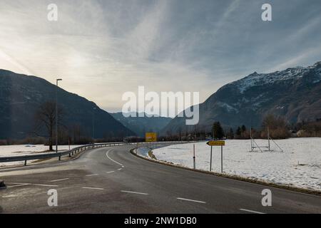 Valle di Bovec in inverno sole, neve intorno alle montagne. Vista verso l'incredibile cascata di Boka, un po' nuvoloso cielo. Foto Stock