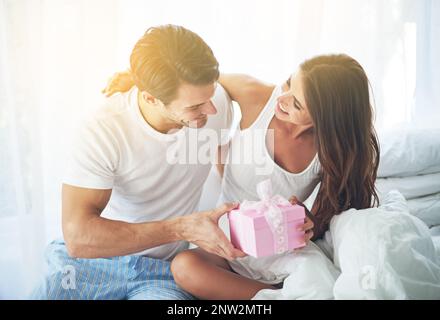 Ive ha ricevuto una piccola sorpresa per te. Scatto di un marito amorevole che dà a sua moglie un regalo. Foto Stock