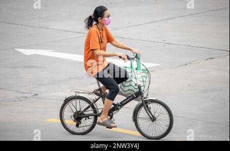 SAMUT PRAKAN, THAILANDIA, 17 2023 FEBBRAIO, Una donna cavalcata in bicicletta su strada della città. Foto Stock