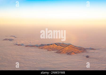 Veduta aerea della cima di una montagna che si erge sopra le nuvole Foto Stock