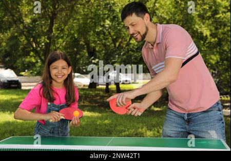 Felice uomo con sua figlia che gioca a ping pong nel parco Foto Stock