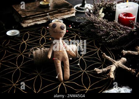 Voodoo bambola trafitto con spilli sul tavolo. Maledizione cerimonia Foto Stock