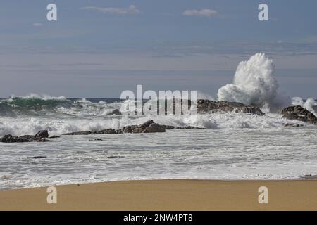 Onda di rottura in una spiaggia rocciosa. Stagione primaverile. Costa rocciosa del Portogallo settentrionale. Foto Stock