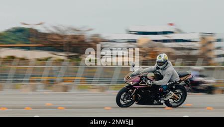 STATI UNITI Jaire Rose, l'ufficiale non incaricato responsabile di 18th Maintenance Group, guida la sua moto attraverso un circuito di addestramento durante l'Advanced Rider Track Day a Naha Port, Okinawa, Giappone, il 11 febbraio 2023. Un certificato ARTD è il più alto livello di formazione con cui il personale dell'accordo di condizione delle forze può essere certificato mentre guida una motocicletta. La formazione è stata organizzata per comprendere meglio come inclinare, accelerare e arrestare correttamente il veicolo. Il corso ha anche garantito che ogni partecipante si sentisse a proprio agio con tutte le tecniche di guida avanzate per aiutare il pr Foto Stock