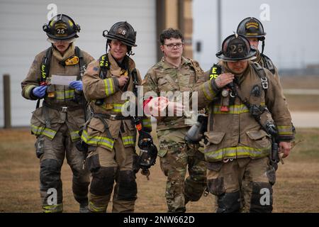 Oklahoma City Vigili del fuoco Vigili del fuoco scorta Stati Uniti Travis Yardley, un paziente simulato con il 137th Force Support Squadron, Oklahoma National Guard, per la sicurezza durante un esercizio di risposta agli incidenti gravi di tornado presso Will Rogers Air National Guard base, Oklahoma City, 8 febbraio 2023. Gli airmen con l'ala di operazioni speciali 137th hanno lavorato insieme ai primi soccorritori dalle agenzie di Oklahoma City durante lo scenario per esercitare le loro tattiche, tecniche e procedure reciproche come se forniscano l'aiuto reciproco in una risposta reale. Foto Stock