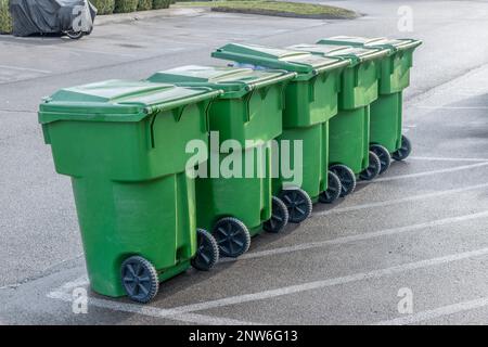 Ripresa orizzontale di taniche per rifiuti in fila in attesa del dumper. Foto Stock