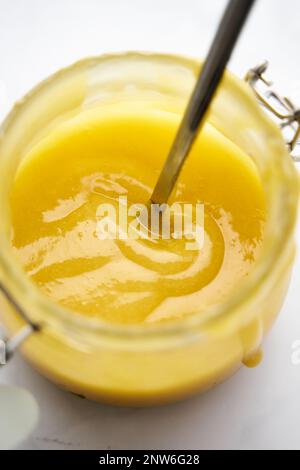 Cagliata di limone in un vaso, cucchiaio che fuoriesce dal vaso, vista dall'alto Foto Stock