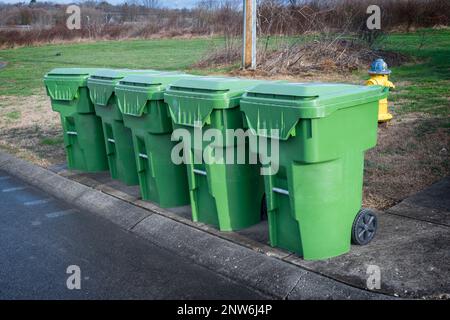 Ripresa orizzontale di una fila di bidoni dei rifiuti in un giorno di camion di scarico. Foto Stock
