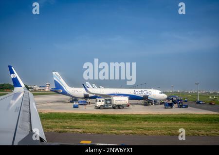 Un grande aereo su una pista che si prepara dal personale dell'aeroporto e dal serbatoio carburante. Preso dalla finestra del piano Foto Stock