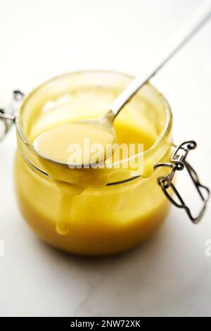 Cagliata di limone in un vaso, cucchiaio che fuoriesce dal vaso, vista dall'alto Foto Stock