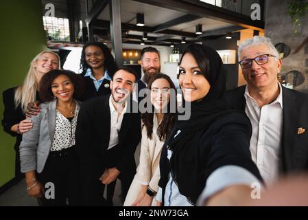 Gruppo multirazziale di uomini d'affari prendere un selfie ritratto sorridente. Foto Stock